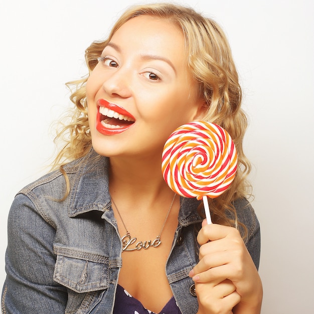 Belle jeune femme avec une grosse sucette colorée