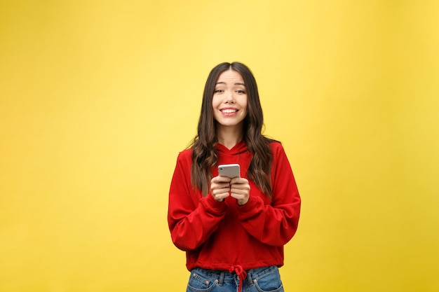 Belle jeune femme heureuse à l'aide de téléphone intelligent.