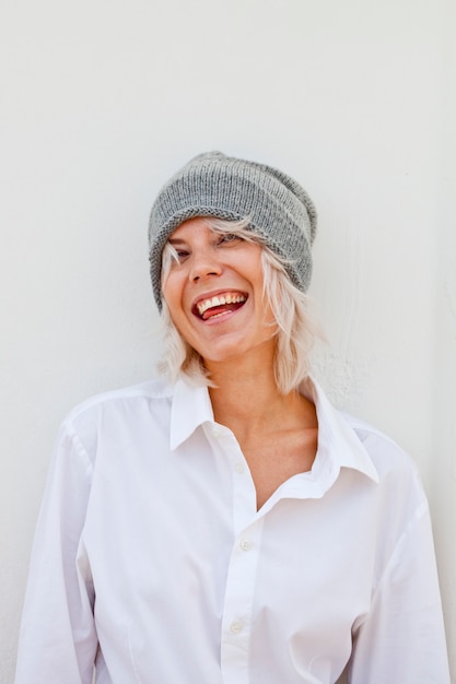 Belle jeune femme heureuse en bonnet gris chaud.