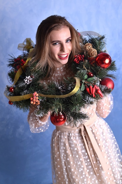 belle jeune femme heureuse avec une couronne de sapin de noël sur la tête