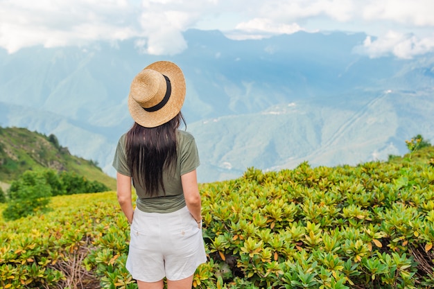 Belle jeune femme heureuse dans les montagnes dans la scène de brouillard