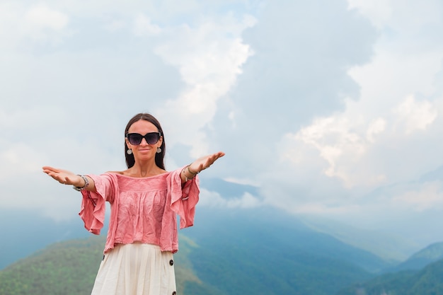 Belle jeune femme heureuse dans les montagnes dans la scène de brouillard