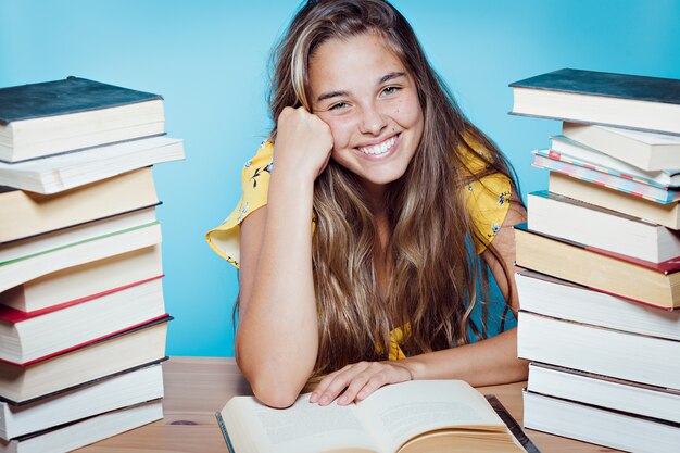 Belle jeune femme heureuse avec des livres