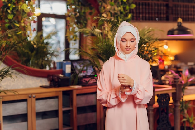 Belle jeune femme avec un hijab rose.