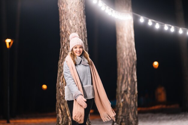 Belle jeune femme en hiver Heure d'hiver heureuse dans la forêt Guirlande lumineuse