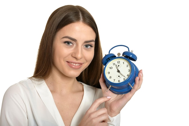 Belle jeune femme avec l'horloge sur fond blanc