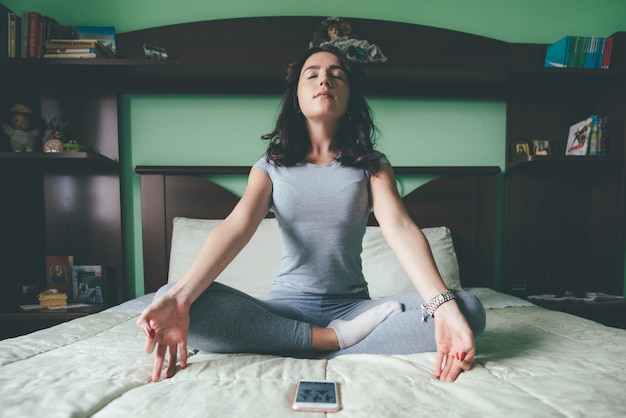 Belle jeune femme à l'intérieur à la maison, faire du yoga