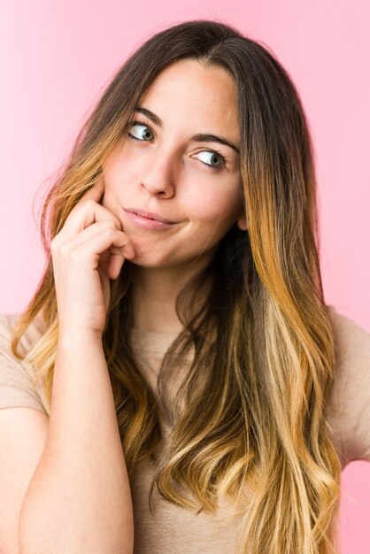 Belle jeune femme isolée sur mur rose