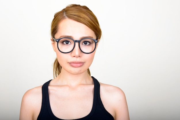 Belle jeune femme japonaise contre le mur blanc