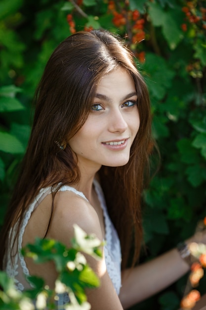 Belle jeune femme jardinant à l'extérieur dans la nature estivale. actes et le concept d'une dépendance d'été, un jardin verdoyant et la liberté