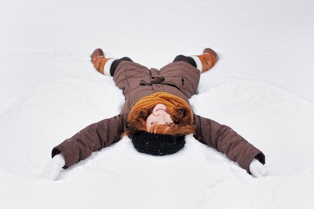 belle jeune femme jouant dans la neige