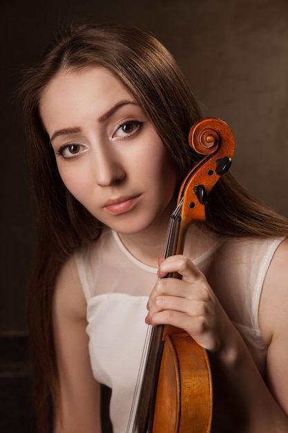 Belle jeune femme jouant du violon sur fond noir