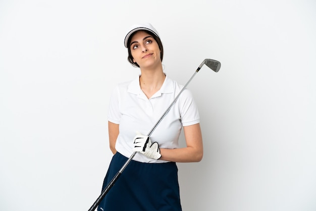 Belle jeune femme de joueur de golfeur isolée sur un mur blanc et levant