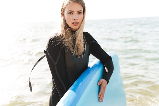 belle jeune femme avec kayak à l'extérieur sur la plage.