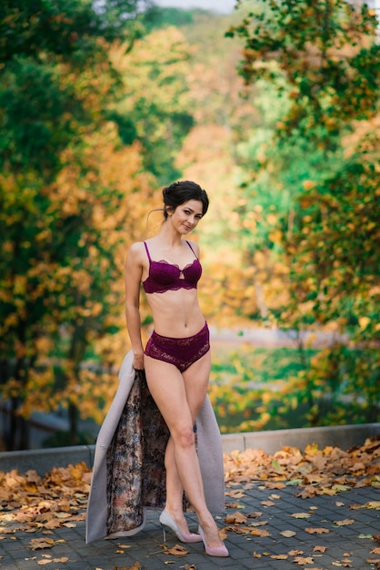 Belle jeune femme en lingerie posant dans la forêt d'automne