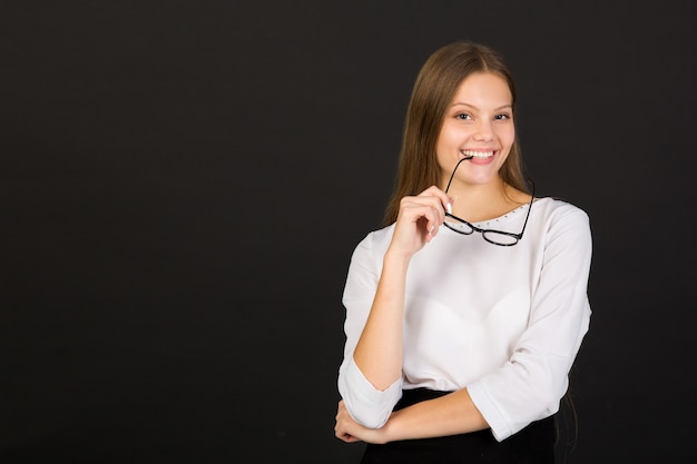 Belle jeune femme à lunettes sur fond noir