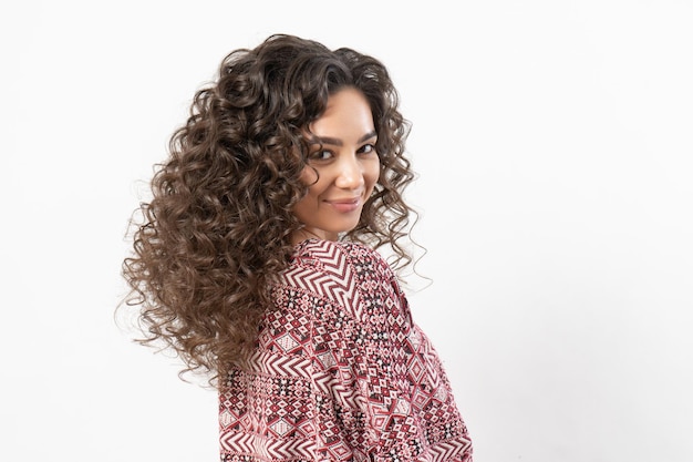 Une belle jeune femme mannequin aux longs cheveux noirs bouclés.