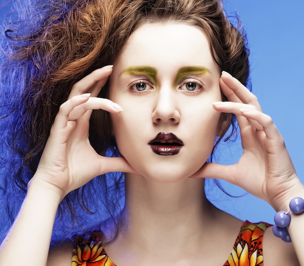 Belle jeune femme avec un maquillage lumineux