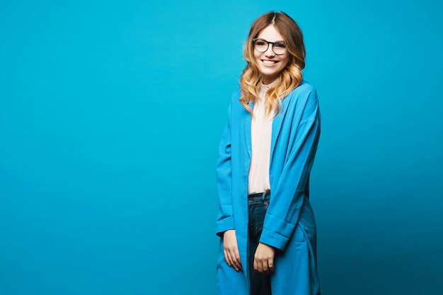 Belle jeune femme avec maquillage naturel et manteau bleu à la mode