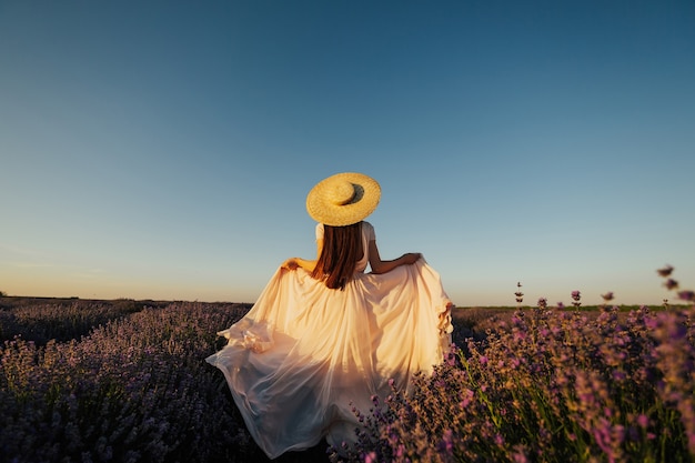 Belle jeune femme marchant dans le champ de lavande en Provence, France.