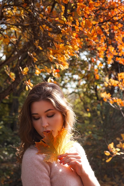 Belle jeune femme marchant dans la forêt d'automne. Temps chaud et ensoleillé. Notion d'automne.