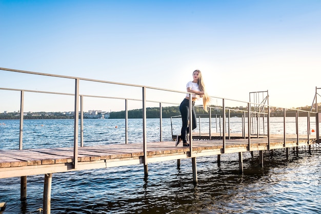 Belle jeune femme marchant dans le parc avec lac