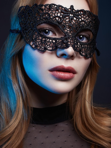 Belle jeune femme en masque de lumières de couleur