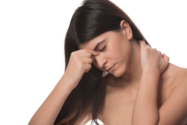 Photo belle jeune femme a des maux de tête, isolé sur fond blanc. portrait de jeune fille épuisée