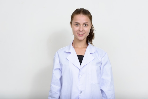 Belle jeune femme médecin contre le mur blanc