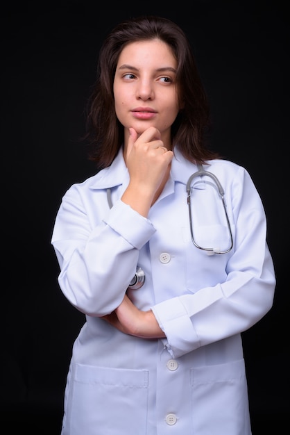 belle jeune femme médecin contre le mur noir