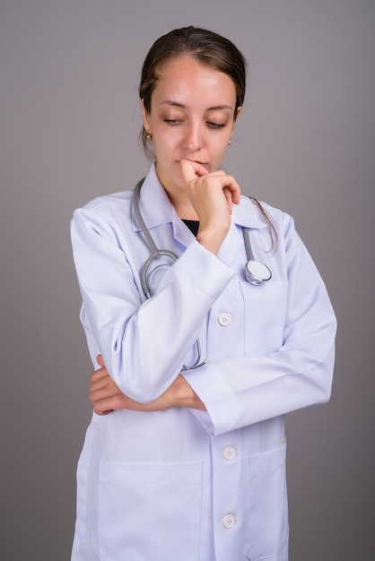 Belle jeune femme médecin sur fond gris