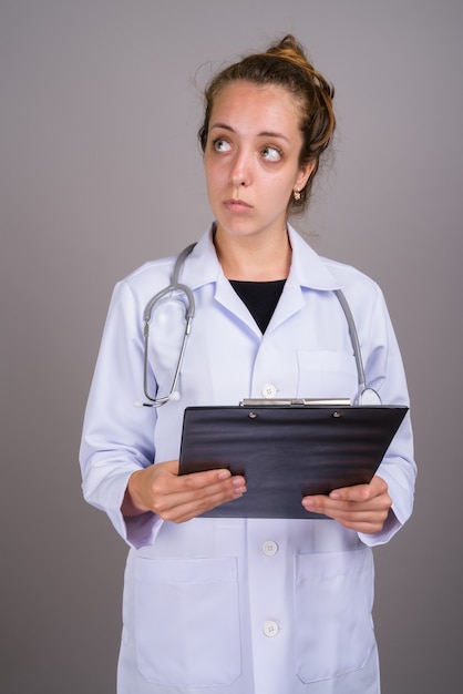 Belle jeune femme médecin sur fond gris