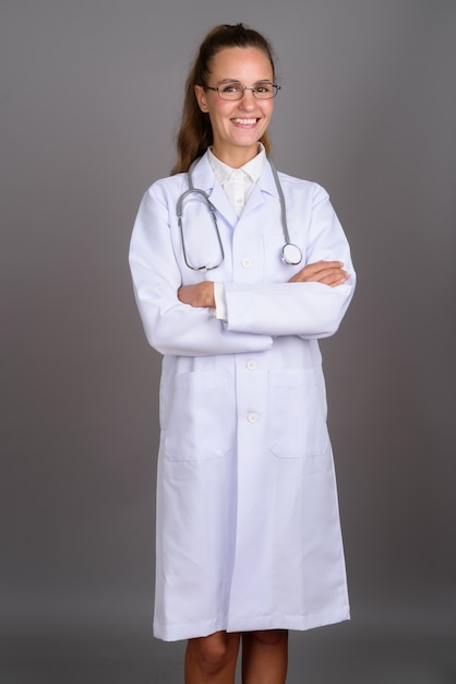 Belle jeune femme médecin sur fond gris