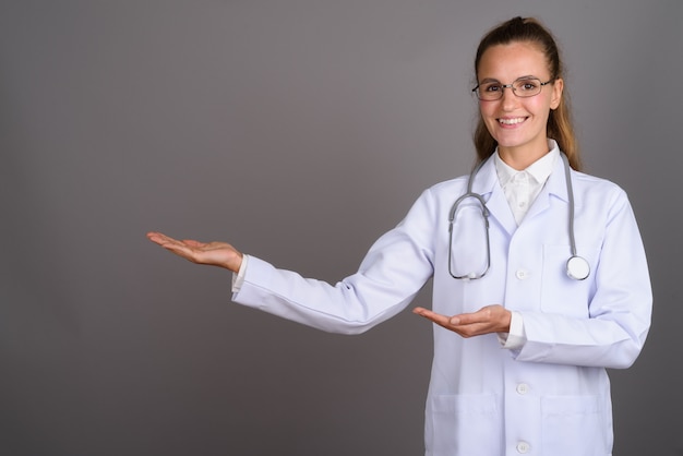 Belle jeune femme médecin sur fond gris