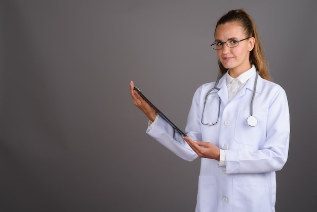 Belle jeune femme médecin sur fond gris