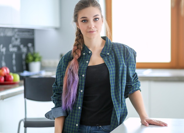 Belle jeune femme médecin souriante assise au bureau et écrivant