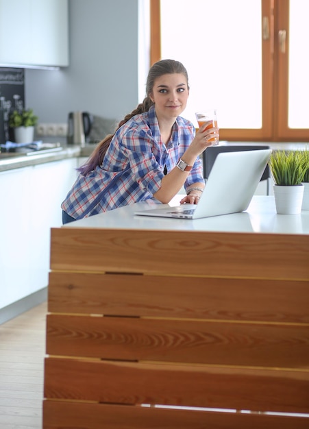 Belle jeune femme médecin souriante assise au bureau et écrivant