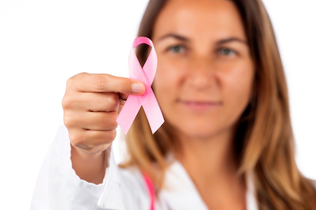 Belle jeune femme médecin avec stéthoscope rose et ruban de sensibilisation rose pour le cancer du sein