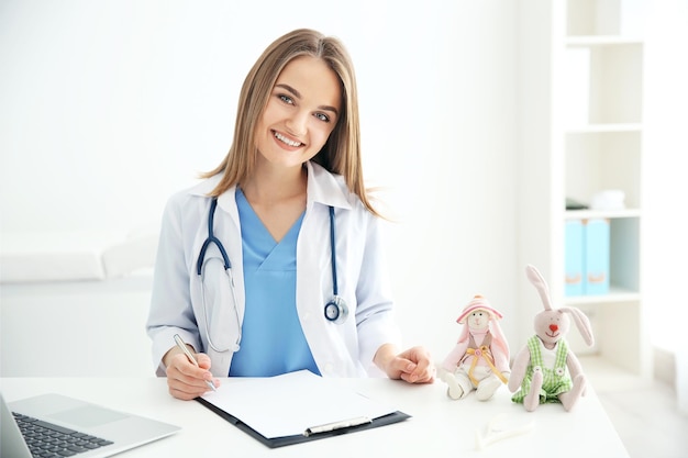 Belle jeune femme médecin travaillant au bureau