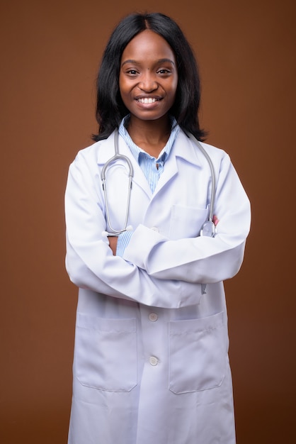 Belle jeune femme médecin zoulou africaine contre backgroundu brun