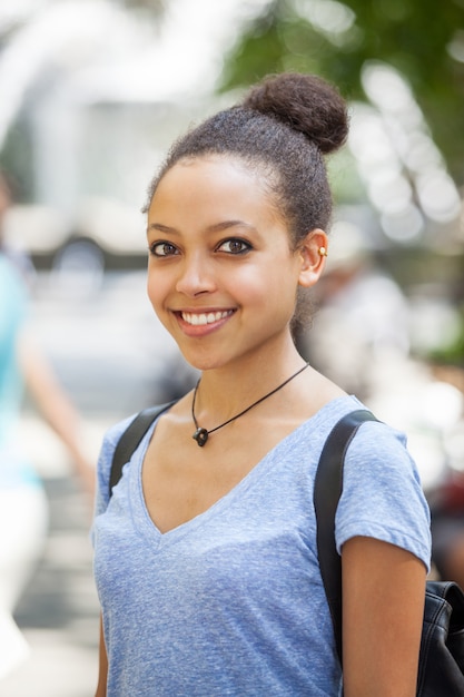 Belle jeune femme métisse au parc, portrait souriant