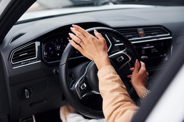 Belle jeune femme à la mode et son automobile moderne