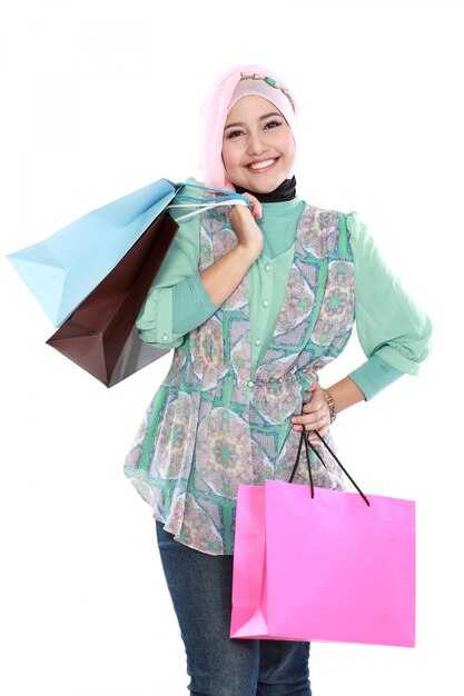 Belle jeune femme musulmane tenant quelques sacs à provisions