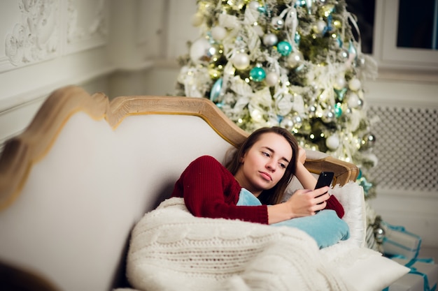 Belle jeune femme à Noël à la maison