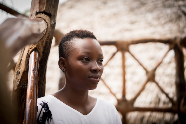 Belle jeune femme noire assise devant la maison