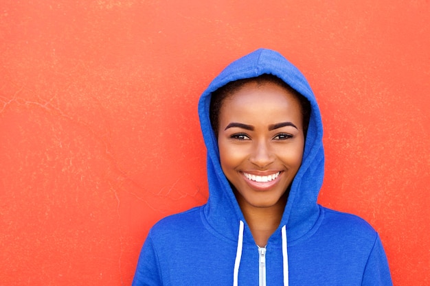 Belle jeune femme noire souriant sur fond rouge