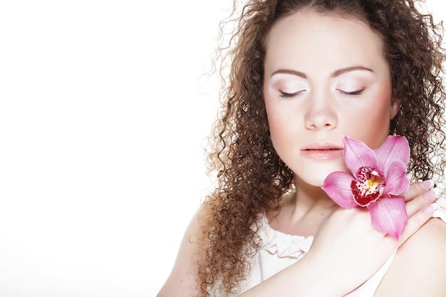 Belle jeune femme avec orchidée rose