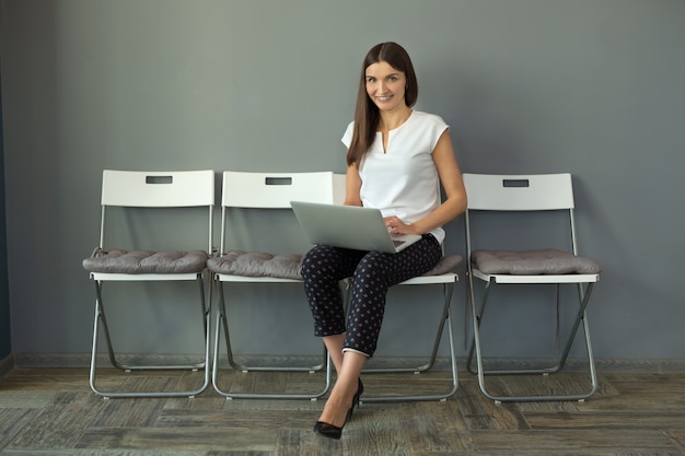 belle jeune femme avec ordinateur portable au bureau