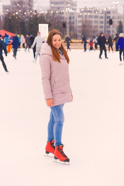 belle jeune femme patinage sur glace