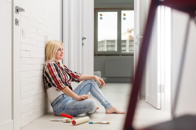 Belle jeune femme peignant le mur dans la chambre